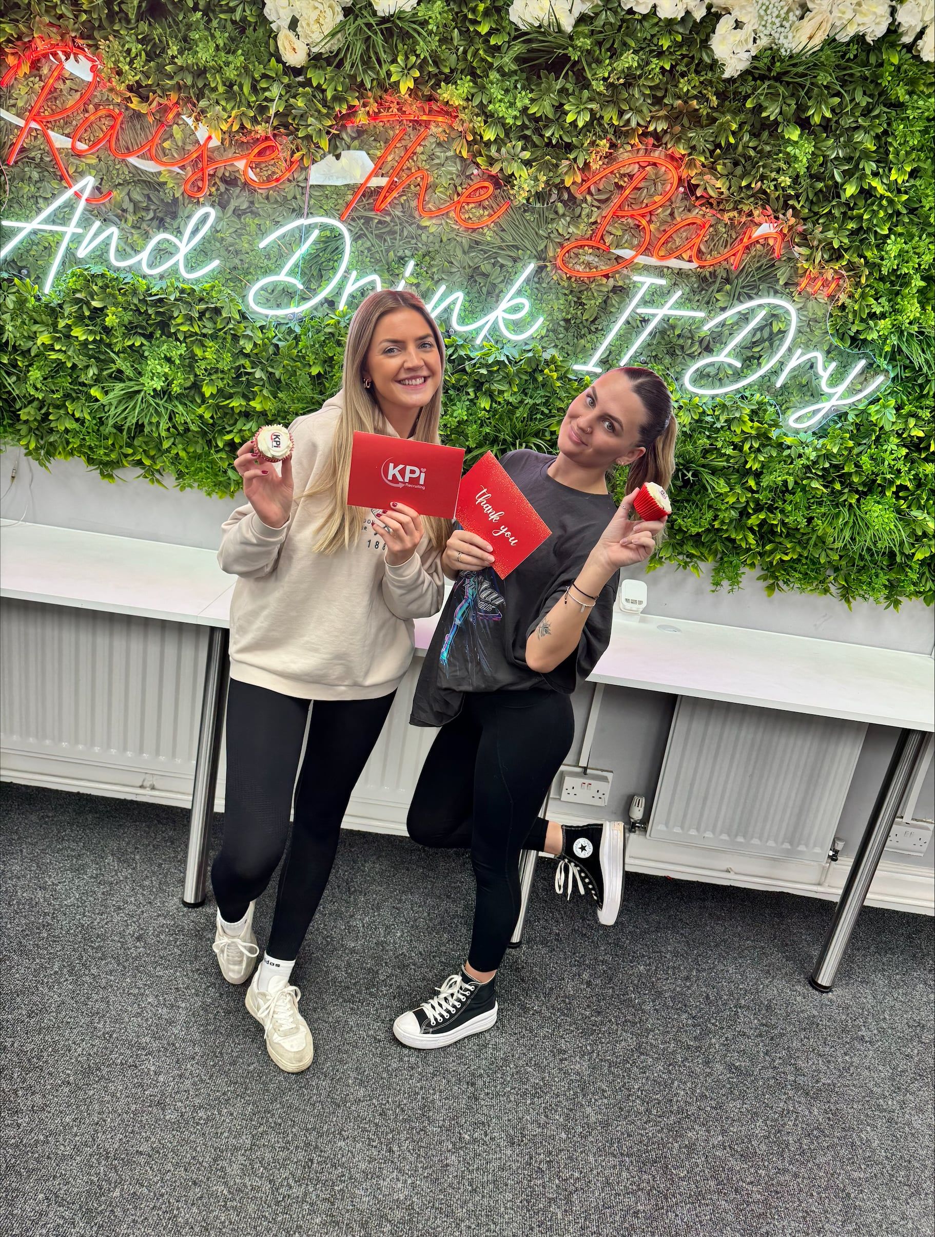 2 girls holding cupcakes and smiling