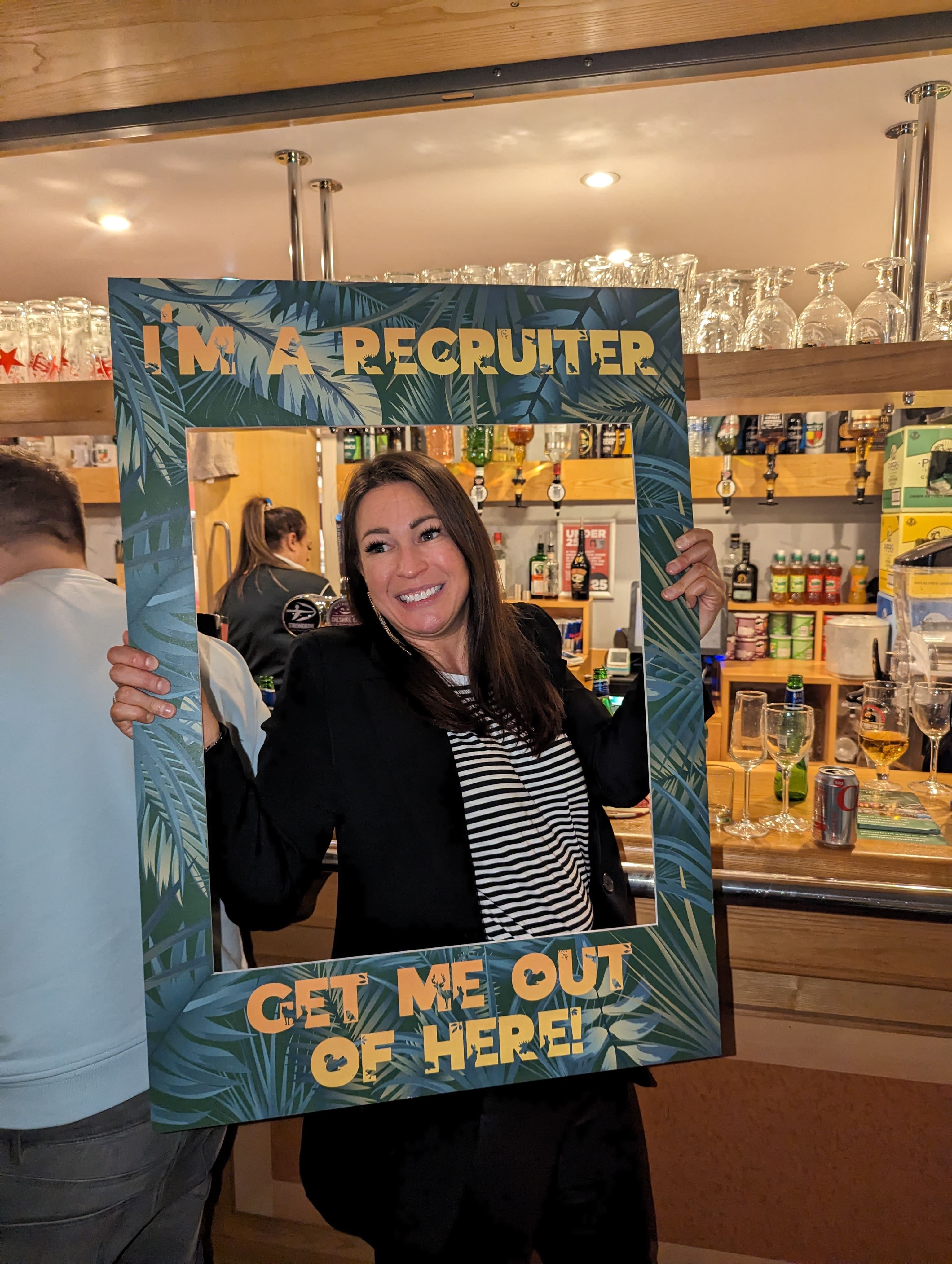 A lady smiling in a selfie frame at a bar.