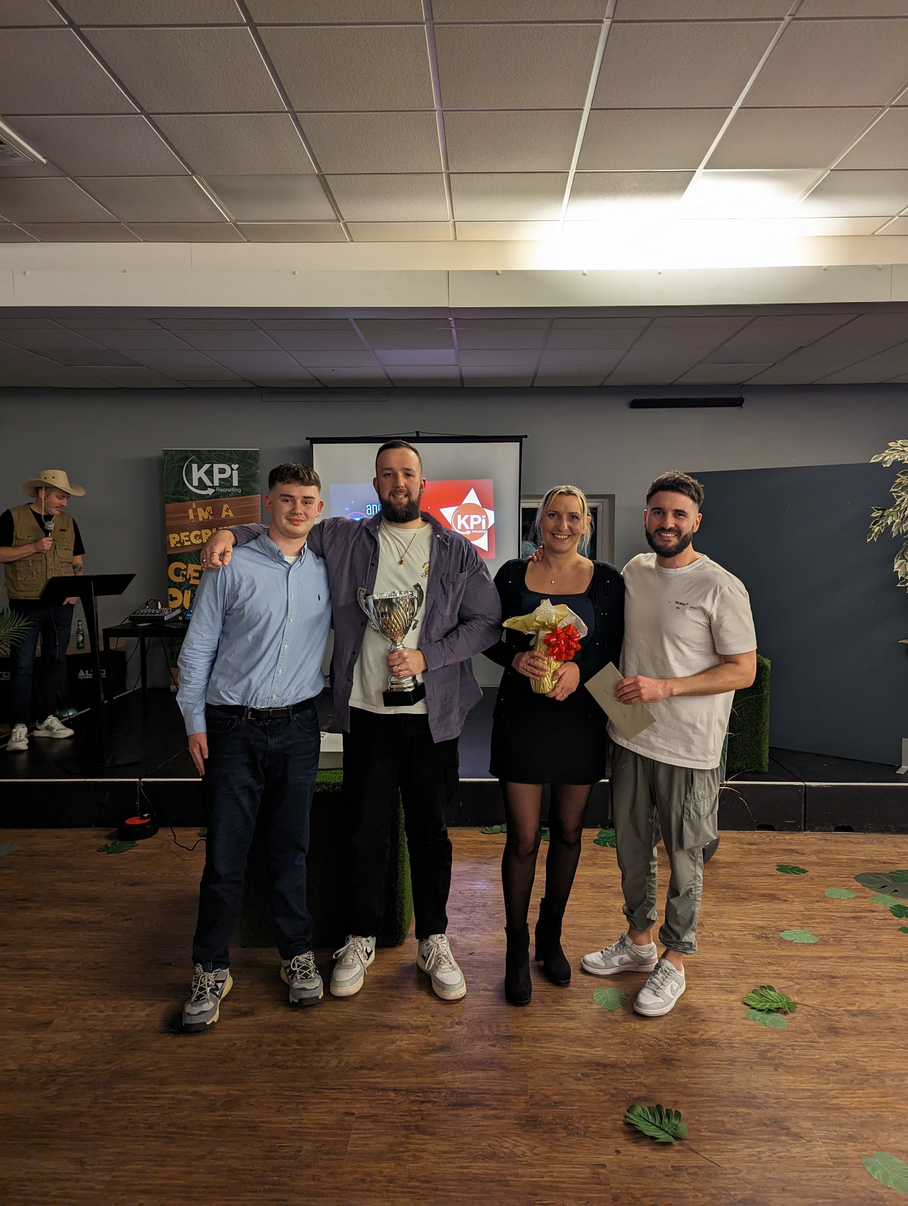 4 colleagues smiling, holding their awards