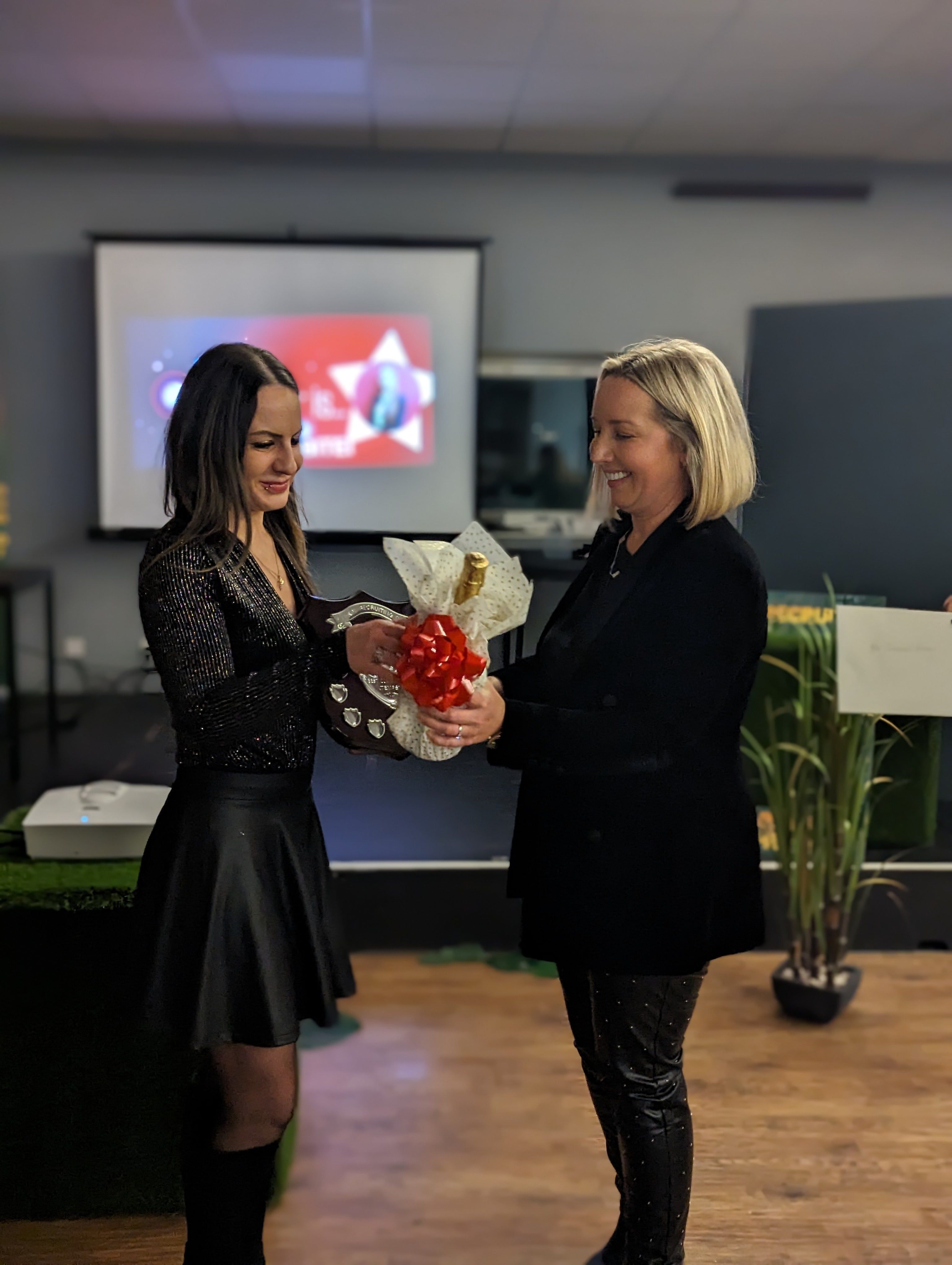 A female receiving her award from her female boss.