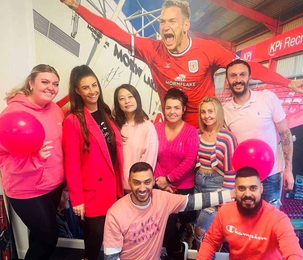 Team dressed in pink posing for a photo