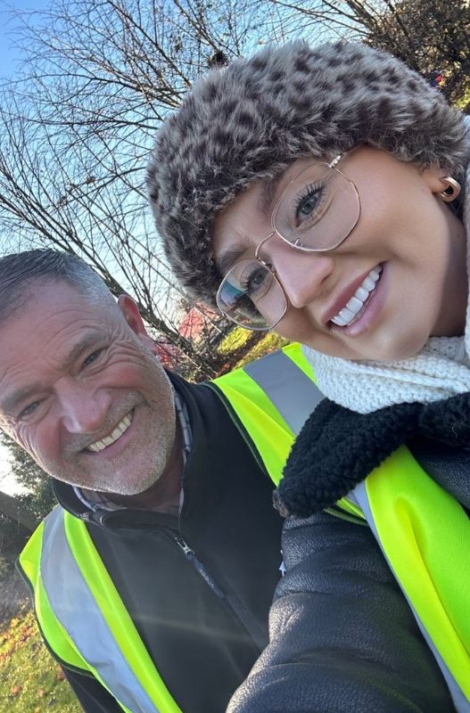 Man and woman taking a selfie wearing hi-vis vests