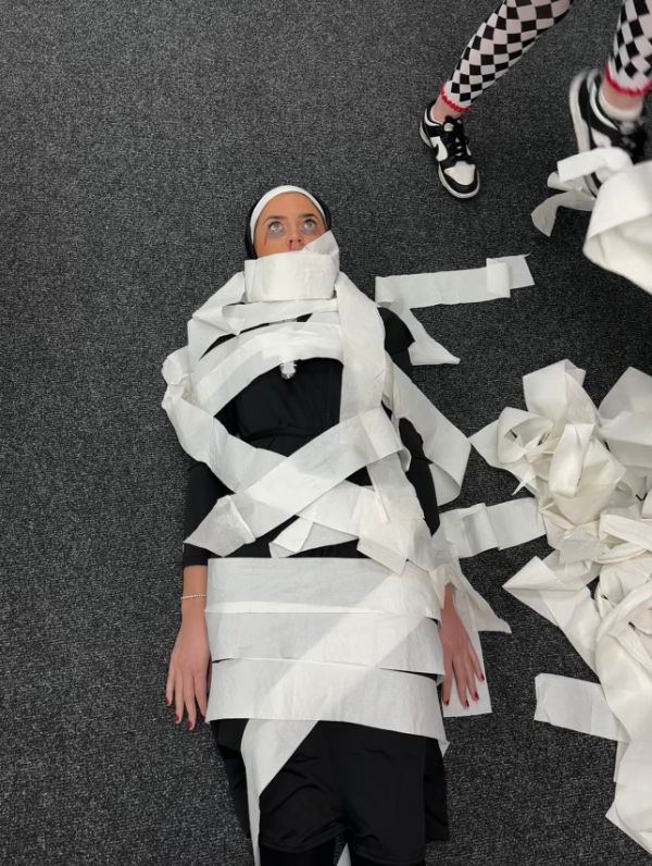 Recruiter lay on the floor, dressed as a nun, wrapped in toilet roll for halloween.