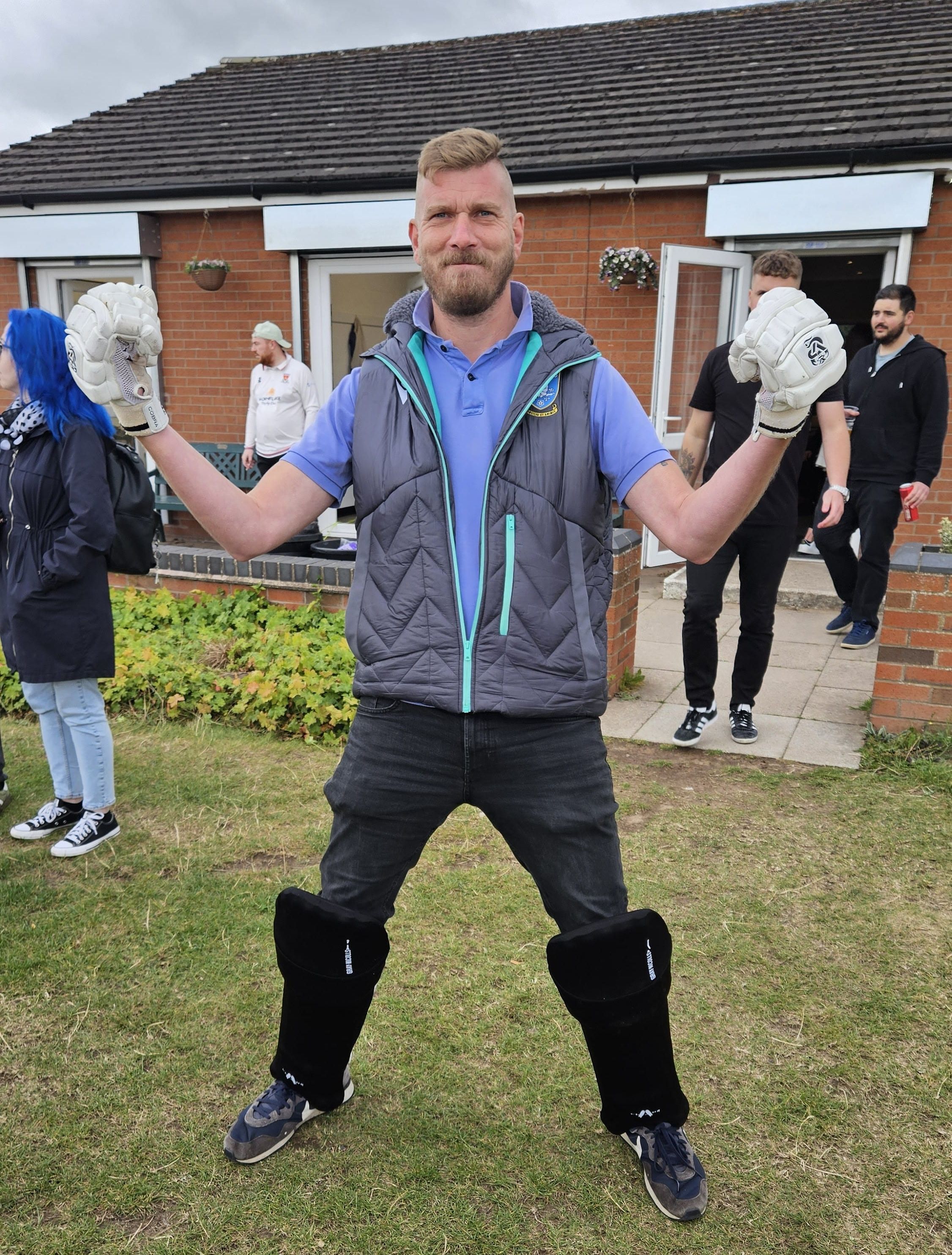 A man in cricket gear posing.