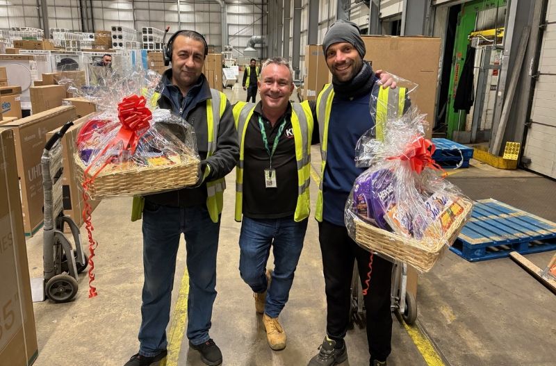 Workers in high vis holding hampers.