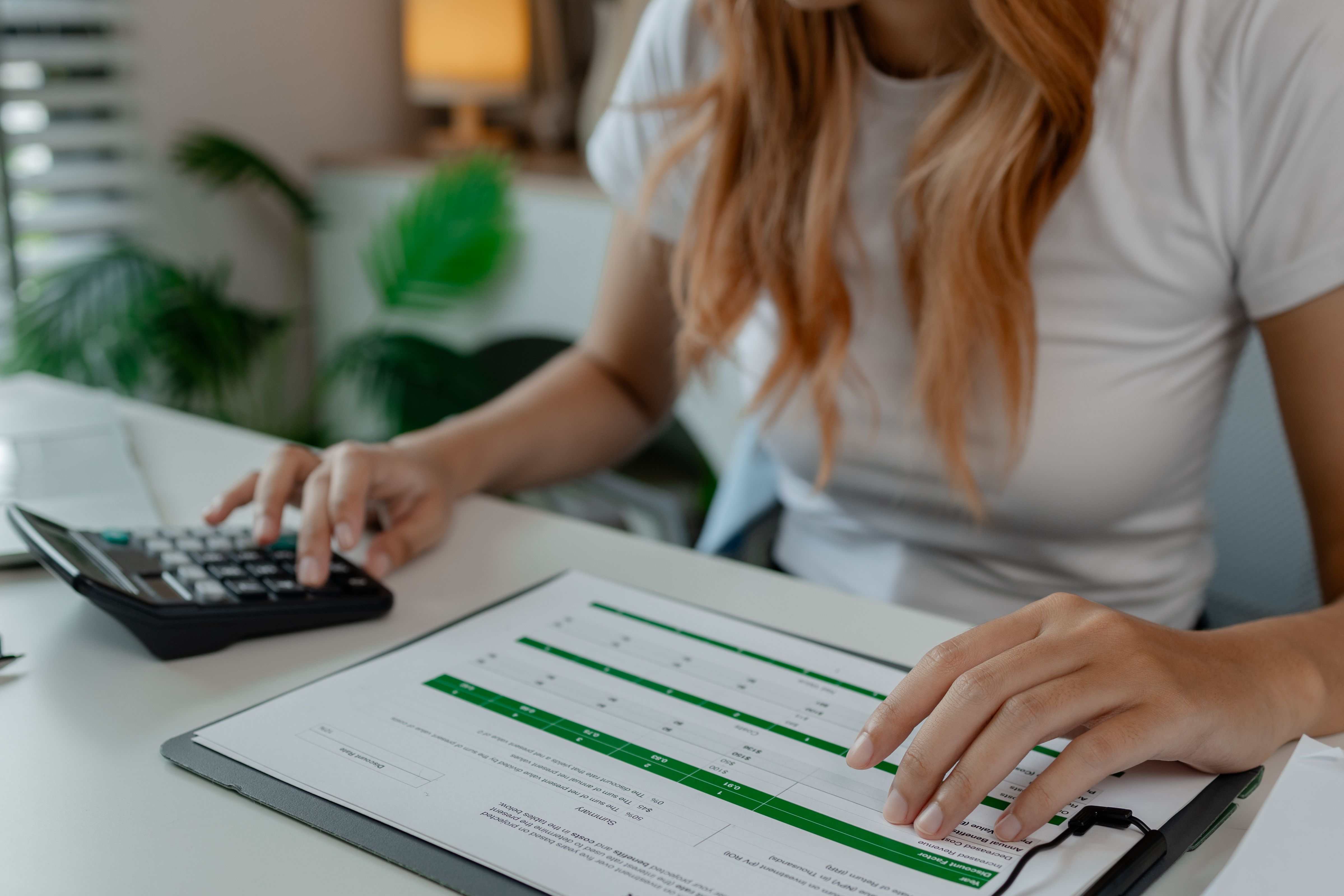 A woman reviewing a document with a calculator