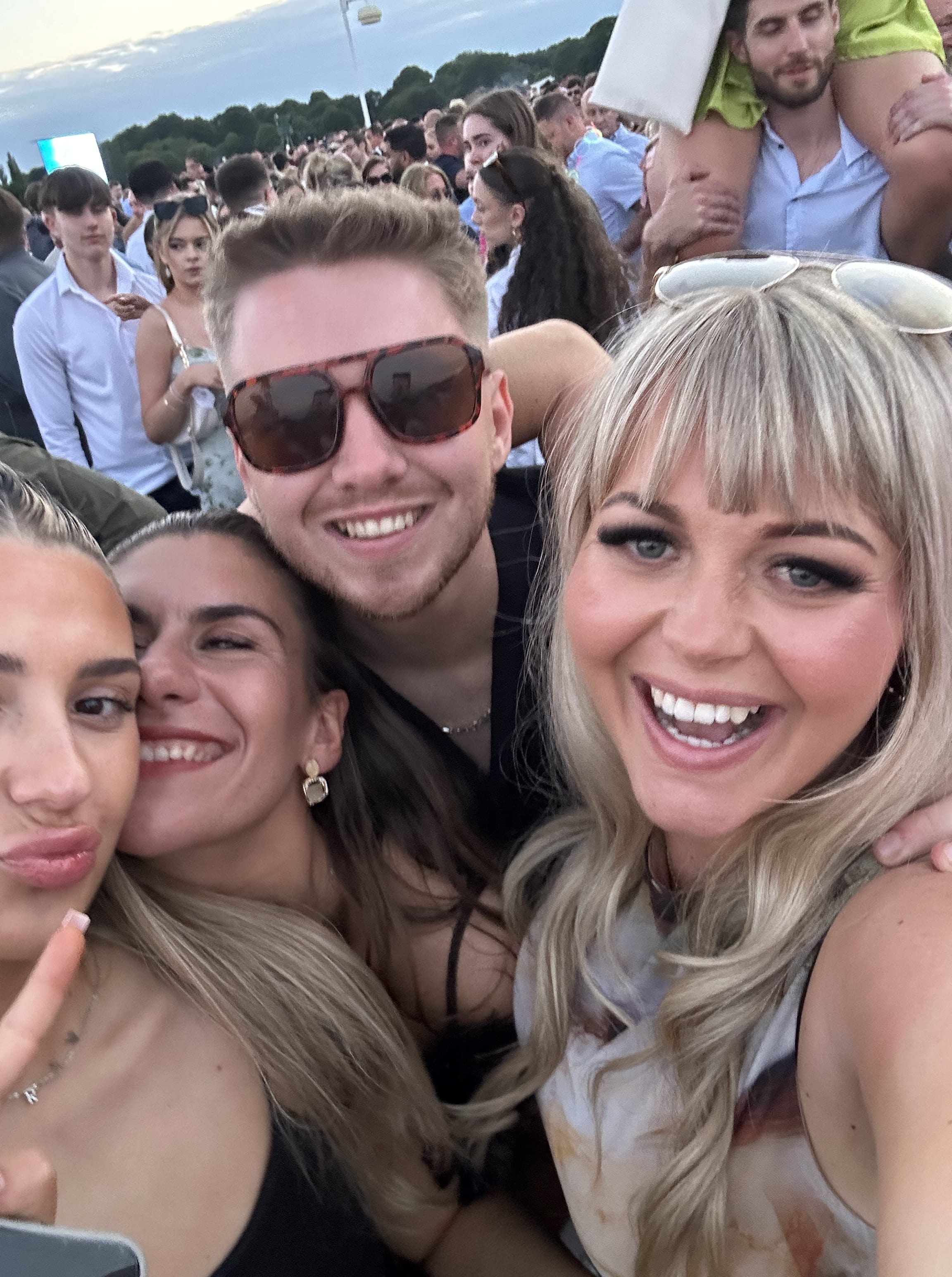 4 friends huddled and smiling at the races.