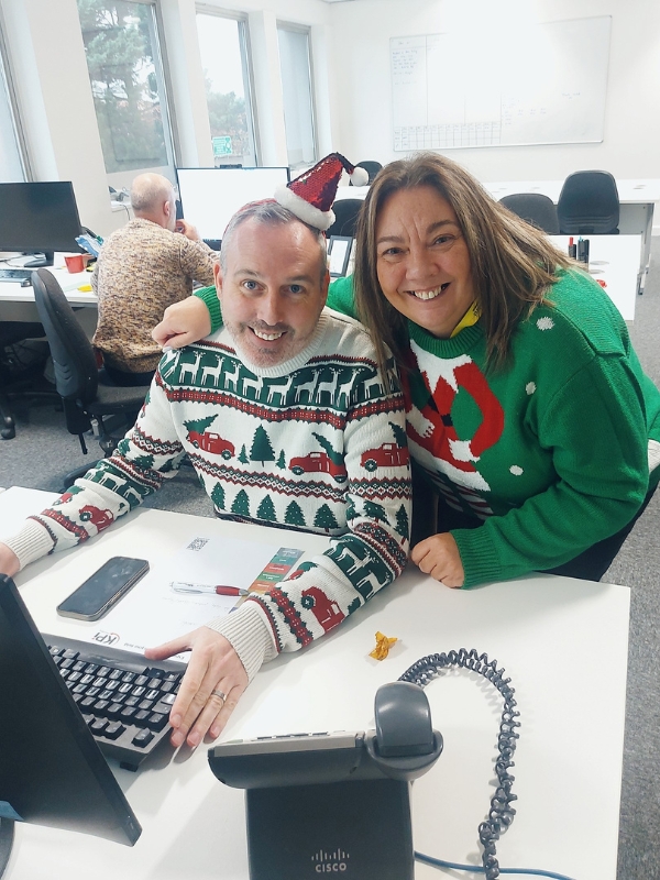 A man and woman in christmas jumpers.