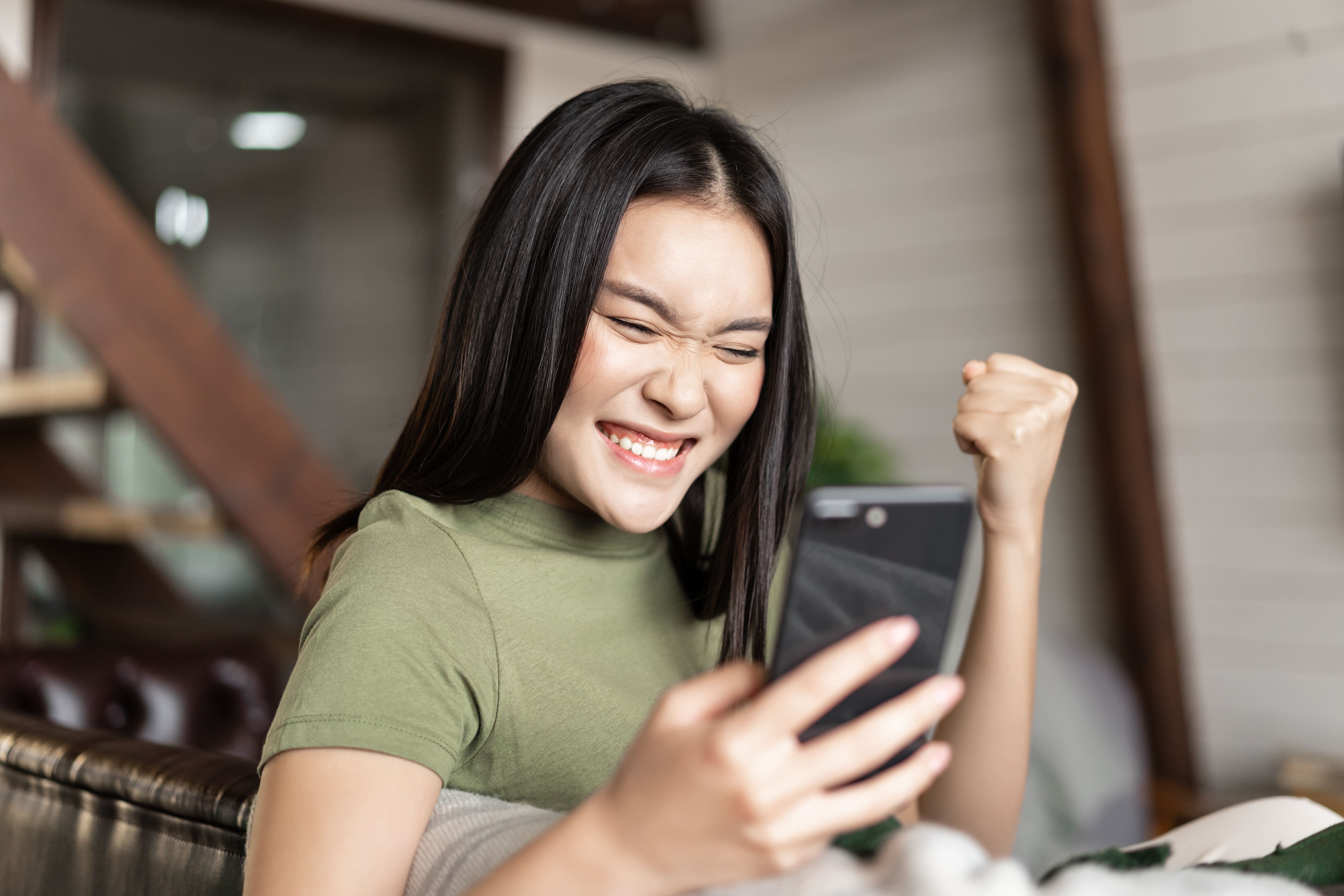 Woman sat on he phone cheering.